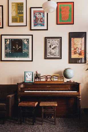 Students gathered around a piano, smiling and learning music in a cozy classroom.
