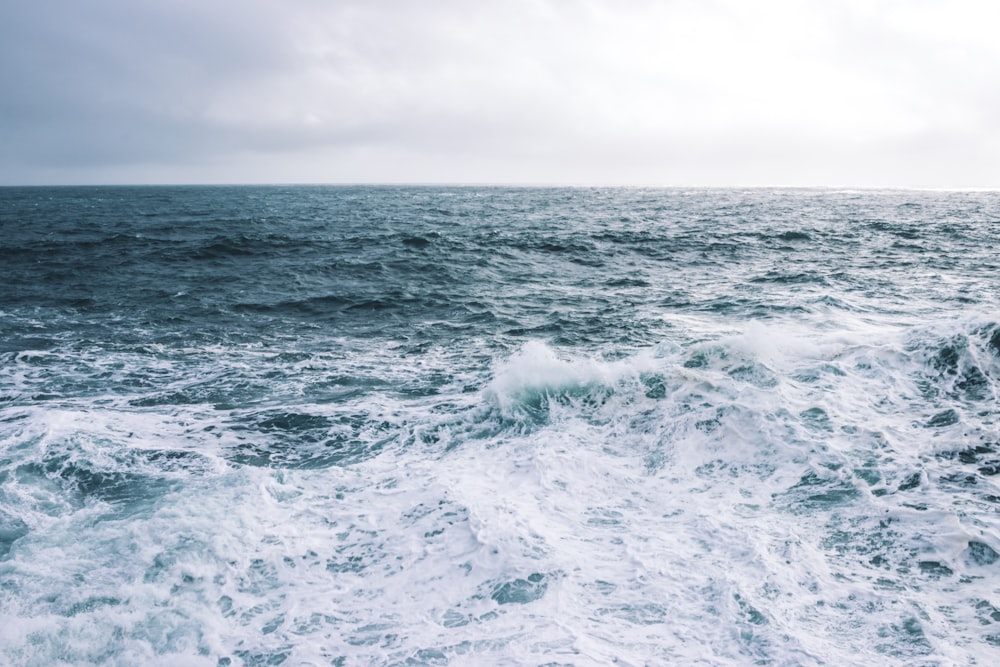 ocean waves under cloudy sky during daytime