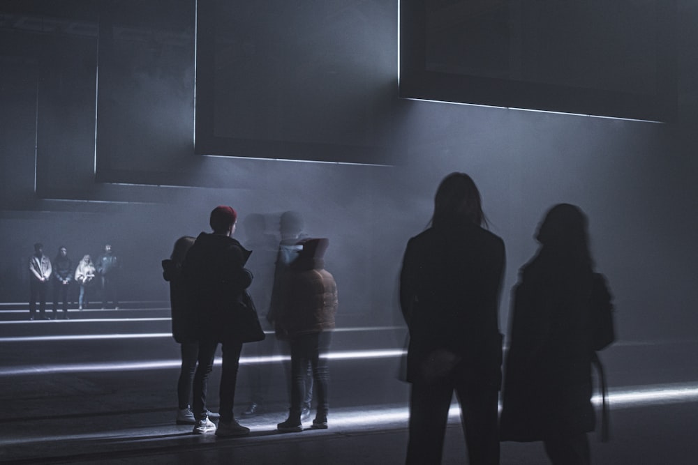 silhouette of 2 person standing in front of black wall