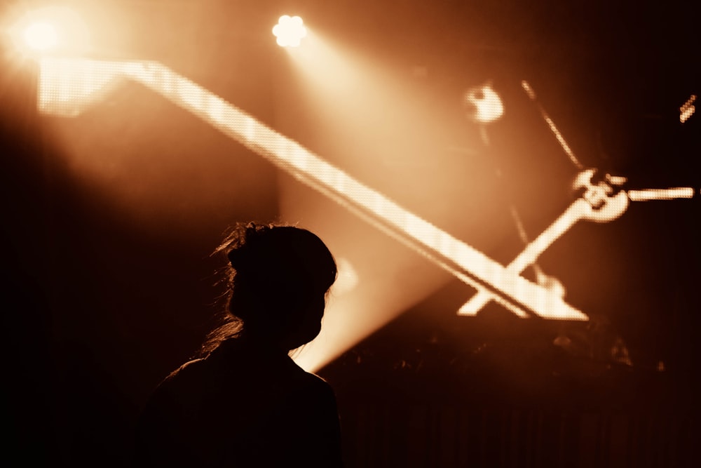 silhouette of person standing near stage light