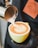 A barista pouring coffee into a cup with latte art.