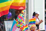 Colorful vivaarco merchandise displayed on a wooden table with pride-themed decorations.
