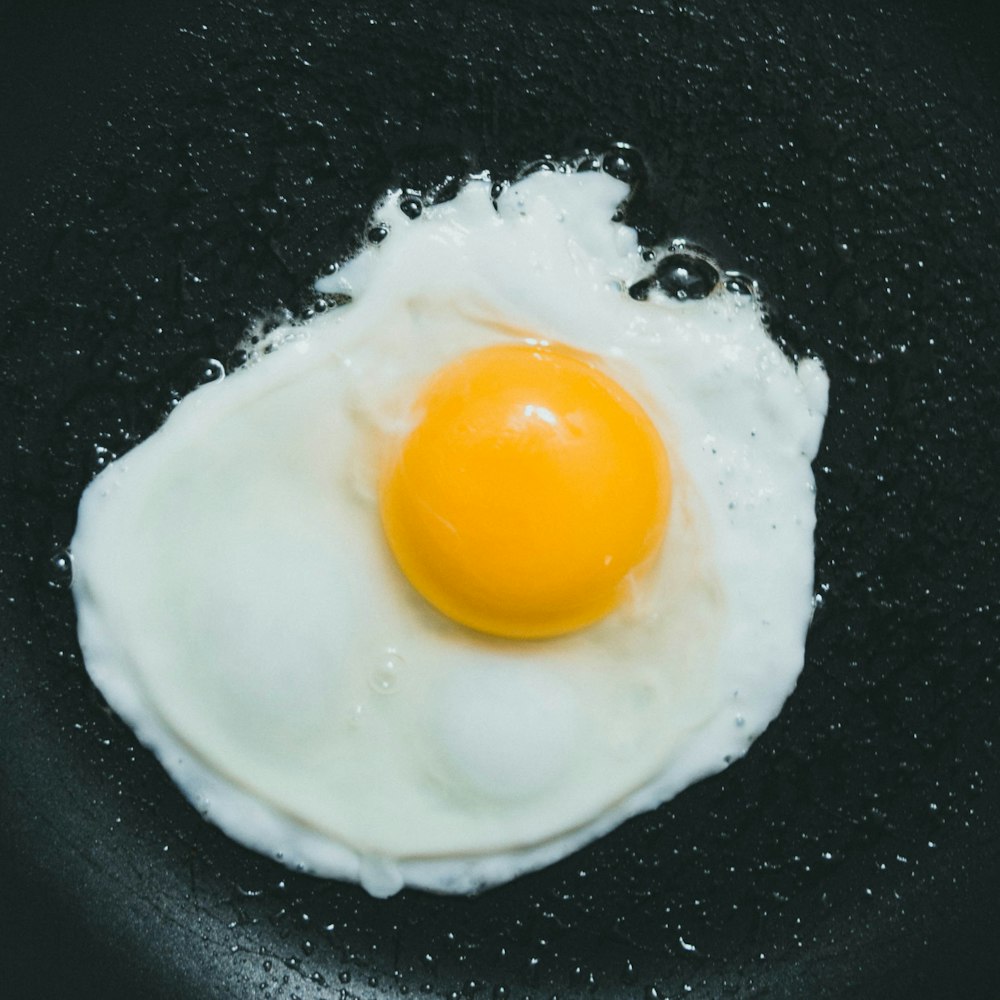 oeuf côté ensoleillé sur assiette noire