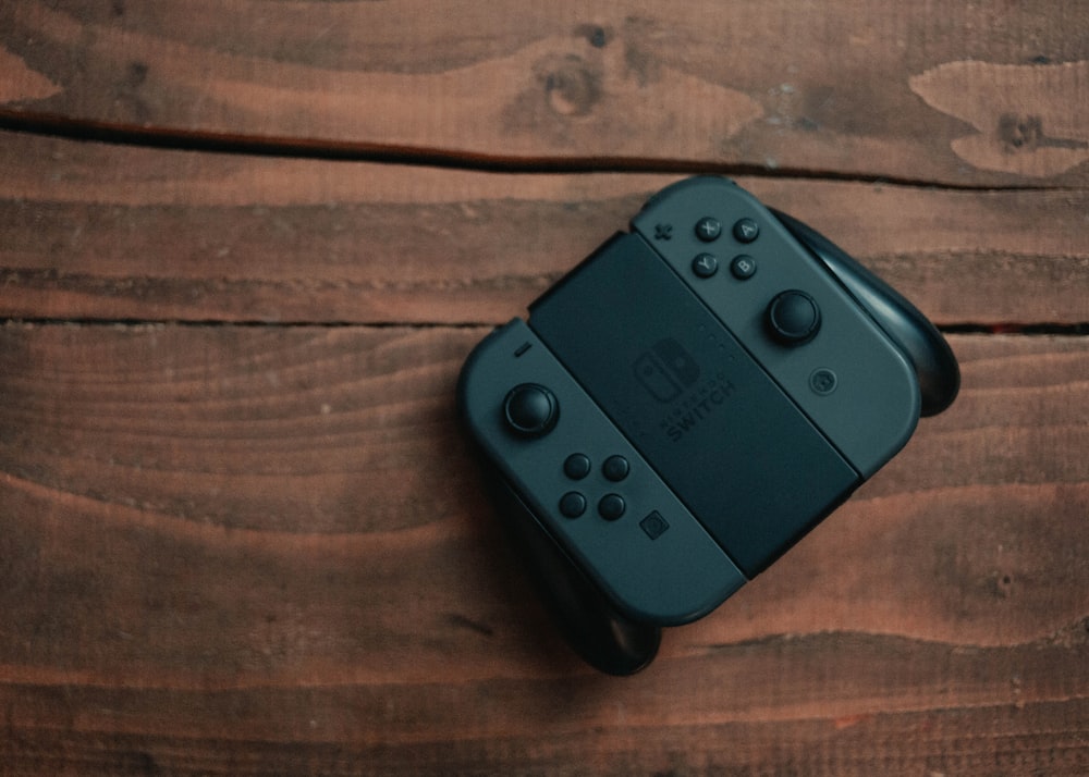 black game controller on brown wooden table