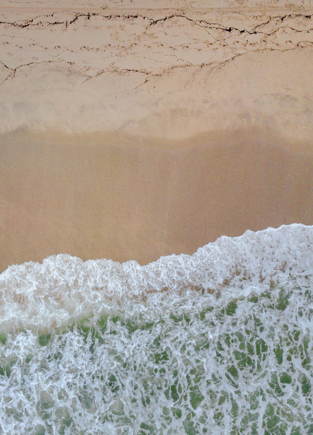 Ein Mann auf einem Surfbrett auf einem wellenbedeckten Strand