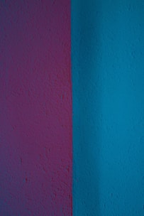 Modern interior wall with vibrant purple and blue textured paint finishes in a stylish living room