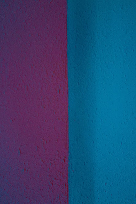 Modern interior wall with vibrant purple and blue textured paint finishes in a stylish living room