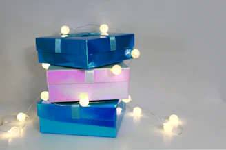 Close-up shot of pastel pink and lavender mystery scoop boxes tied with satin ribbons glowing softly.