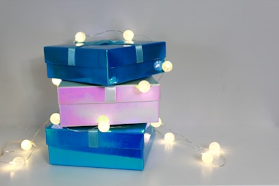 An array of playful, neatly wrapped toymi party favor boxes in blue, pink, and green hues stacked on a table