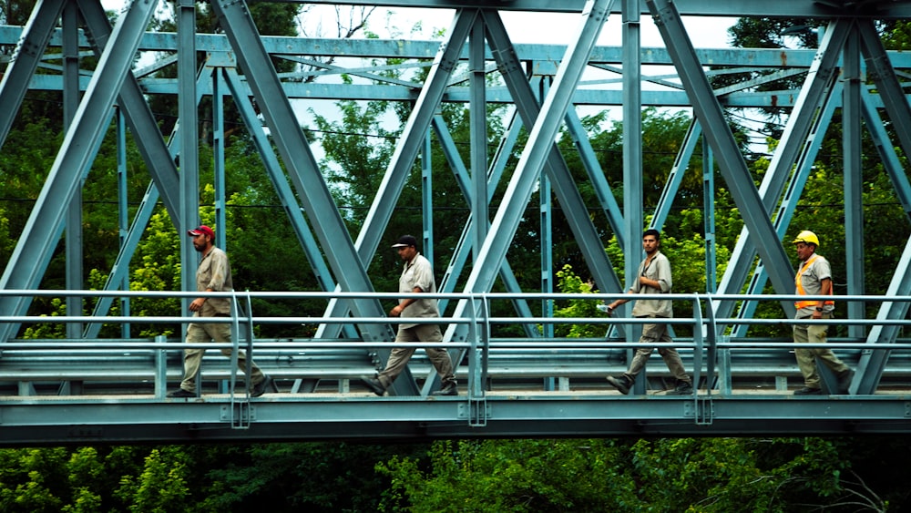man in white shirt standing on gray metal bridge