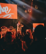 Wunmi performing live on stage with vibrant lighting and an engaged audience.