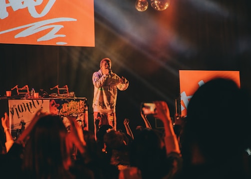 Wunmi performing live on stage with vibrant lighting and an engaged audience.