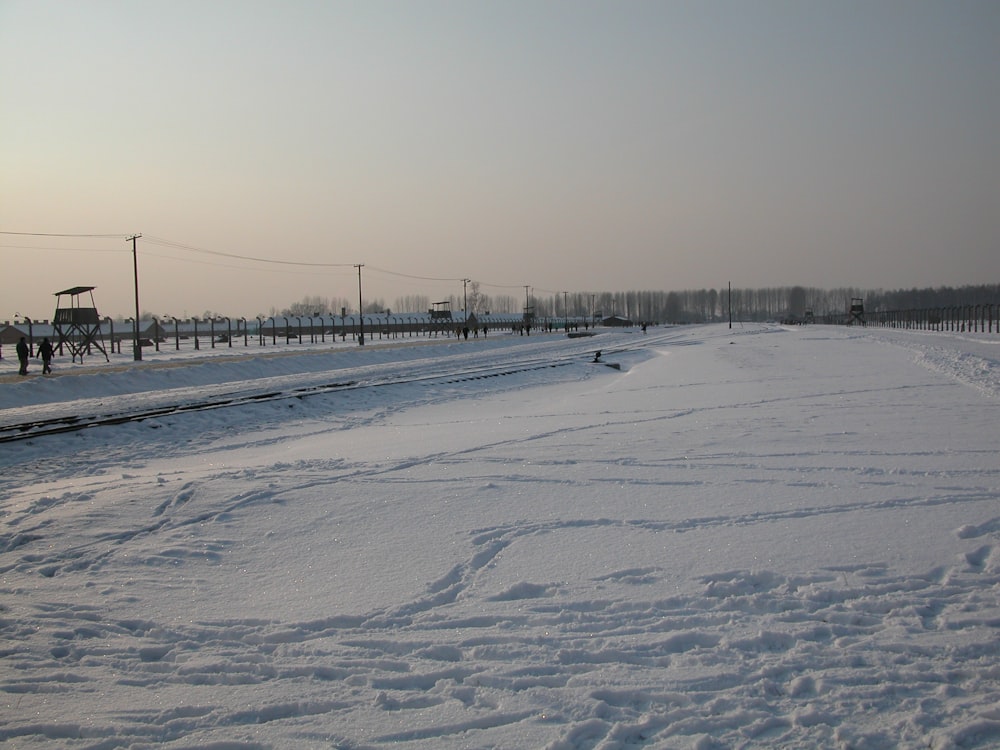 campo coberto de neve com ponte durante o dia