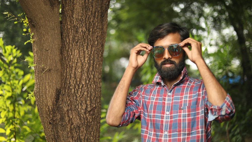 man in red blue and white plaid button up shirt wearing black sunglasses