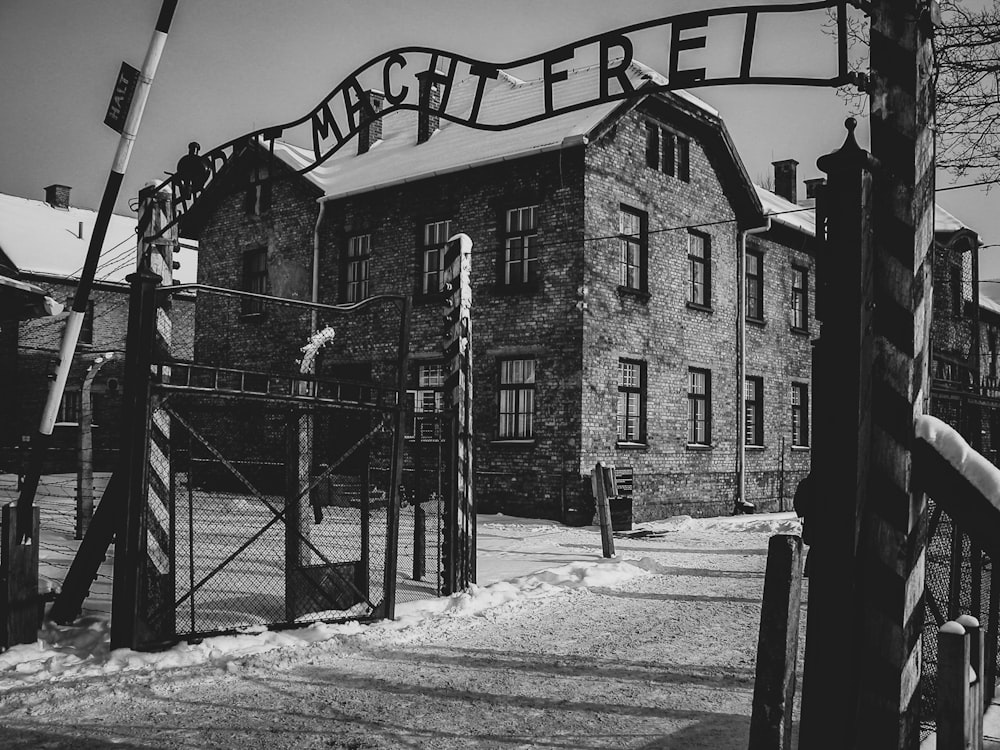 Photo en niveaux de gris d’une route enneigée près d’un bâtiment