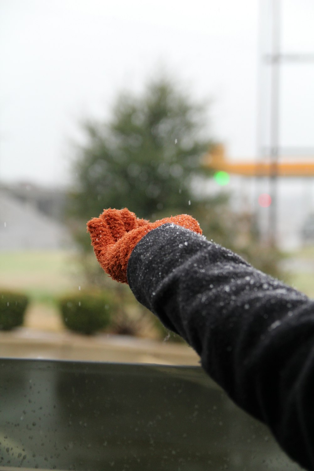 Person in schwarzem Langarmshirt mit orangefarbenem Strickstoff