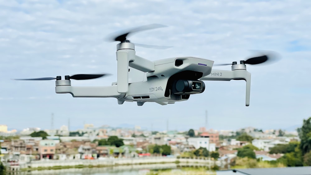 white and black drone flying over city buildings during daytime
