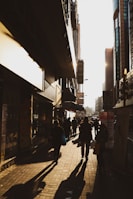 An urban street scene with dynamic shadows and candid human interaction.
