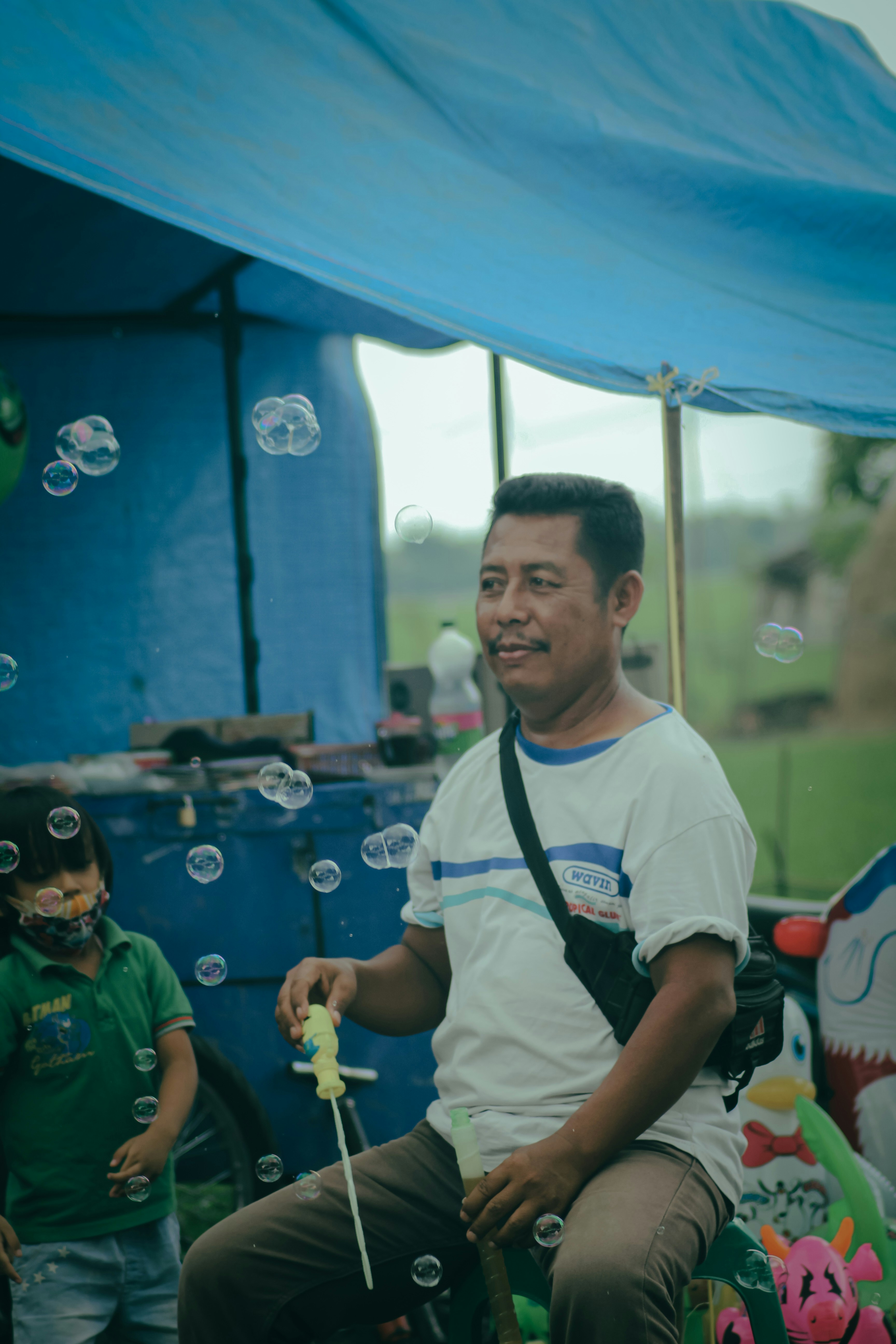 Anak laki-laki berbaju putih dan biru crew neck T-shirt bermain gelembung