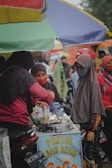 people in red and black hijab sitting on chair during daytime