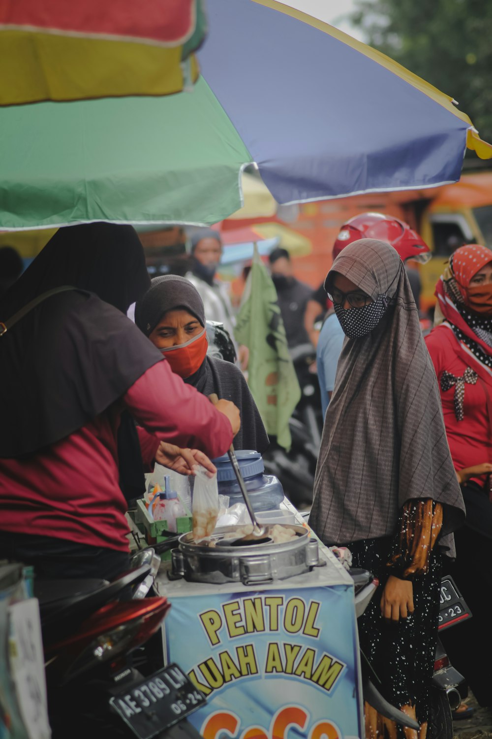 people in red and black hijab sitting on chair during daytime