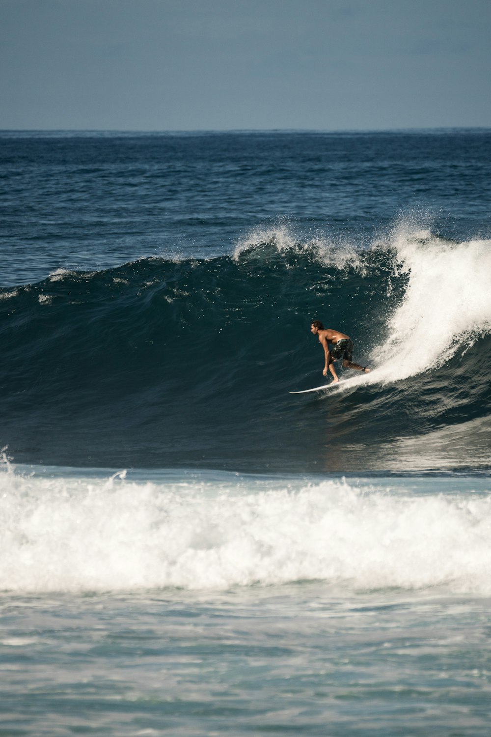 man surfing on sea waves during daytime