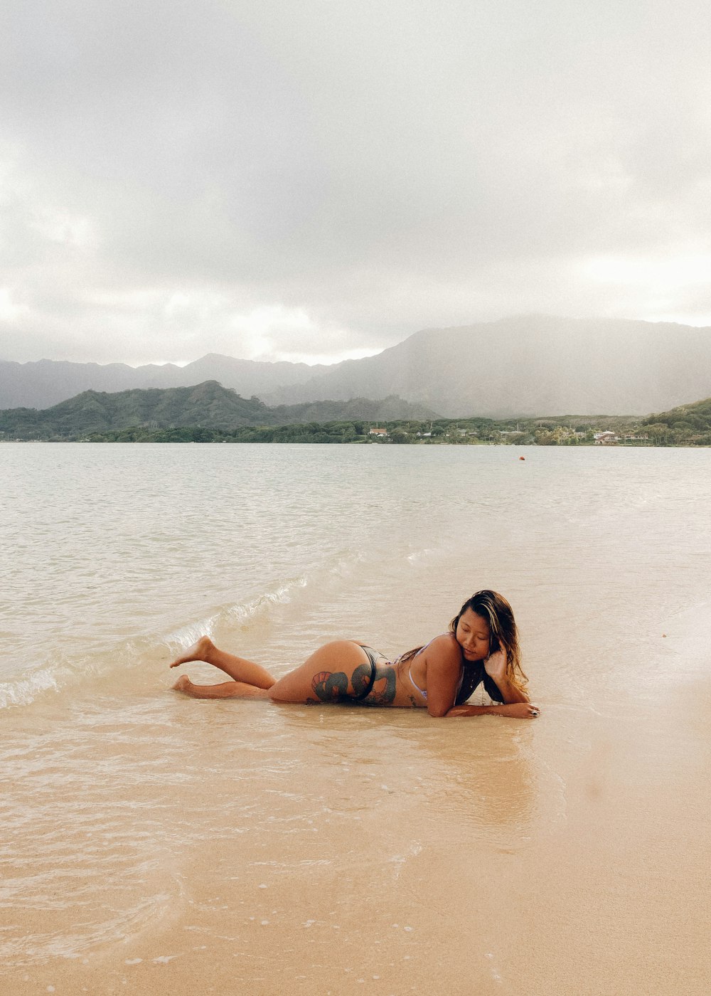 woman in blue bikini lying on beach during daytime