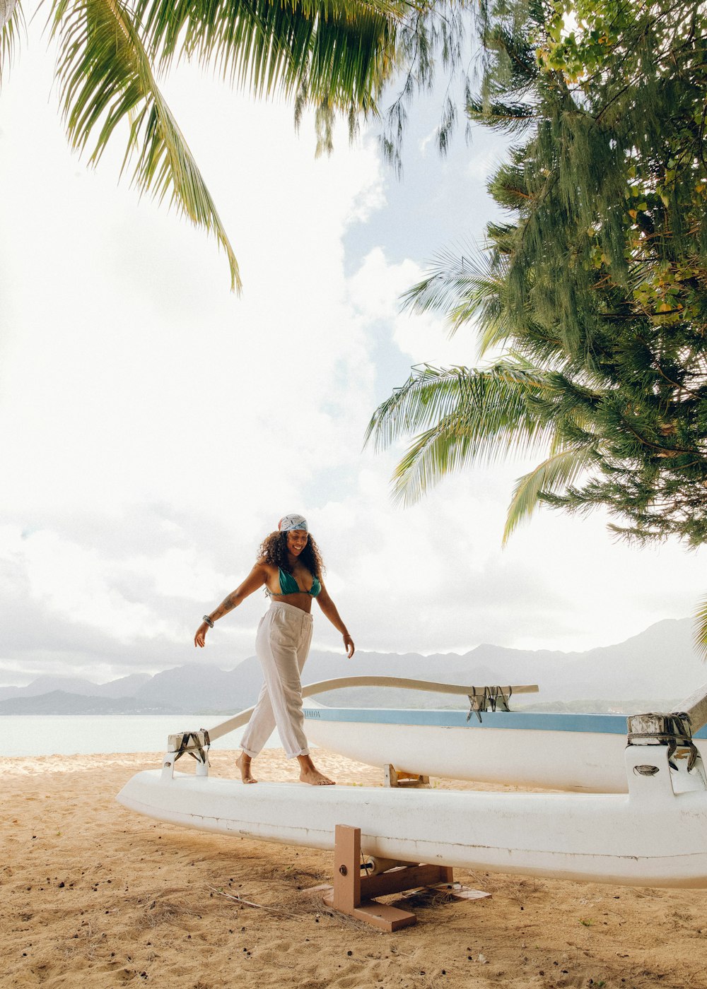woman in white dress standing on white sand near body of water during daytime