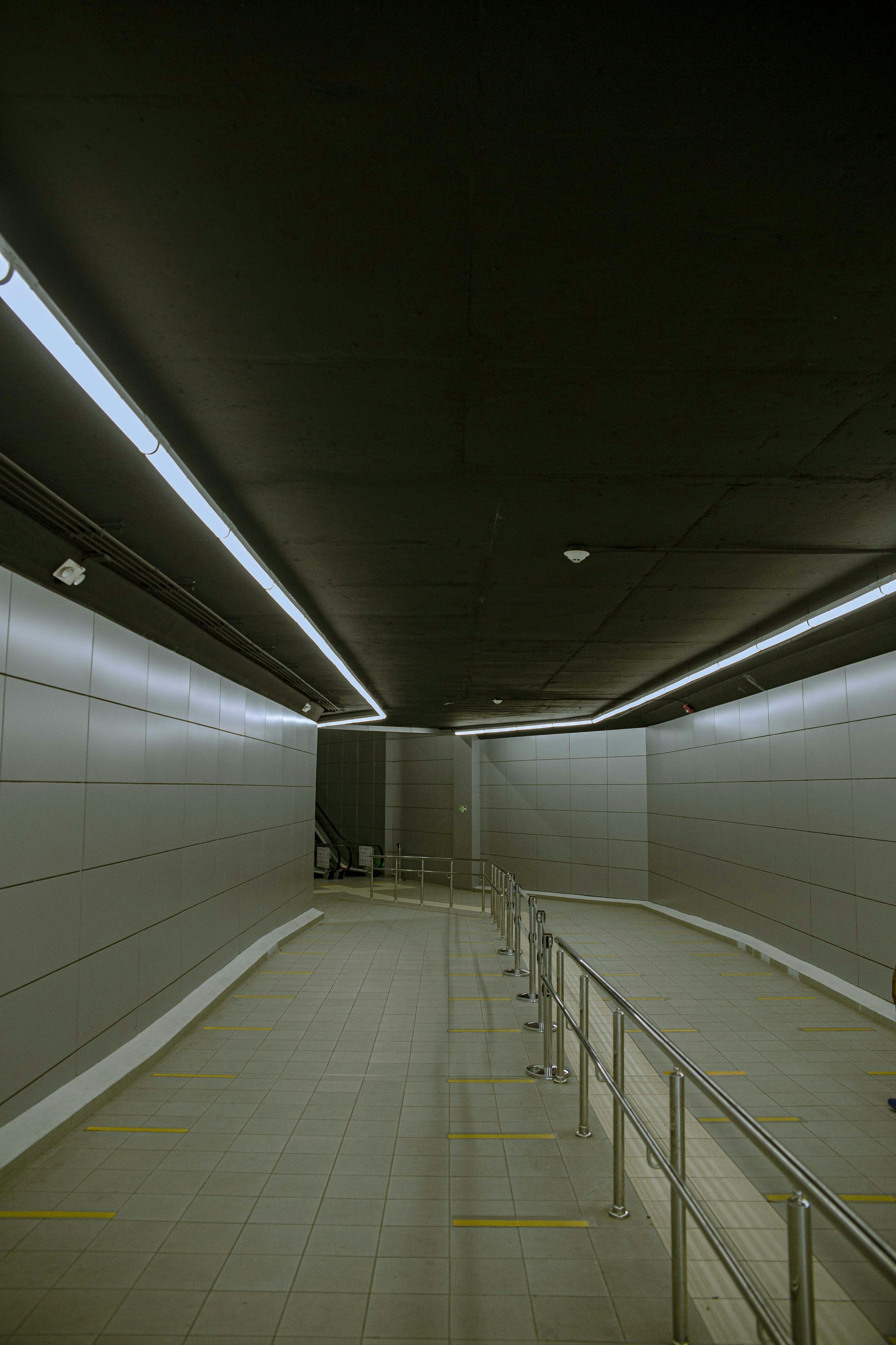 white tiled hallway with stainless steel railings