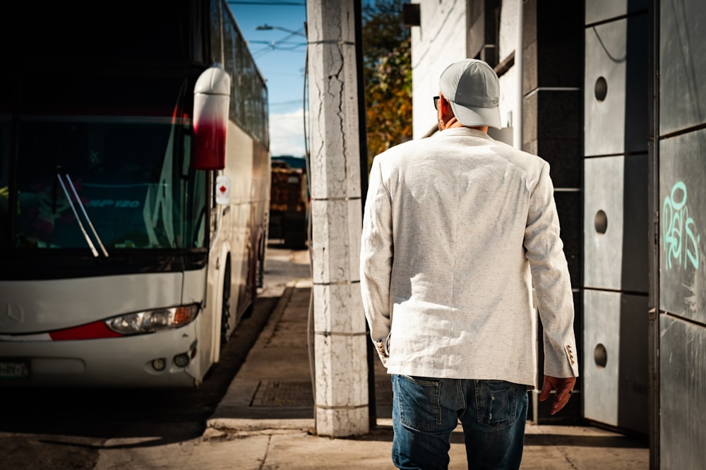 man in white hoodie standing near white van during daytime