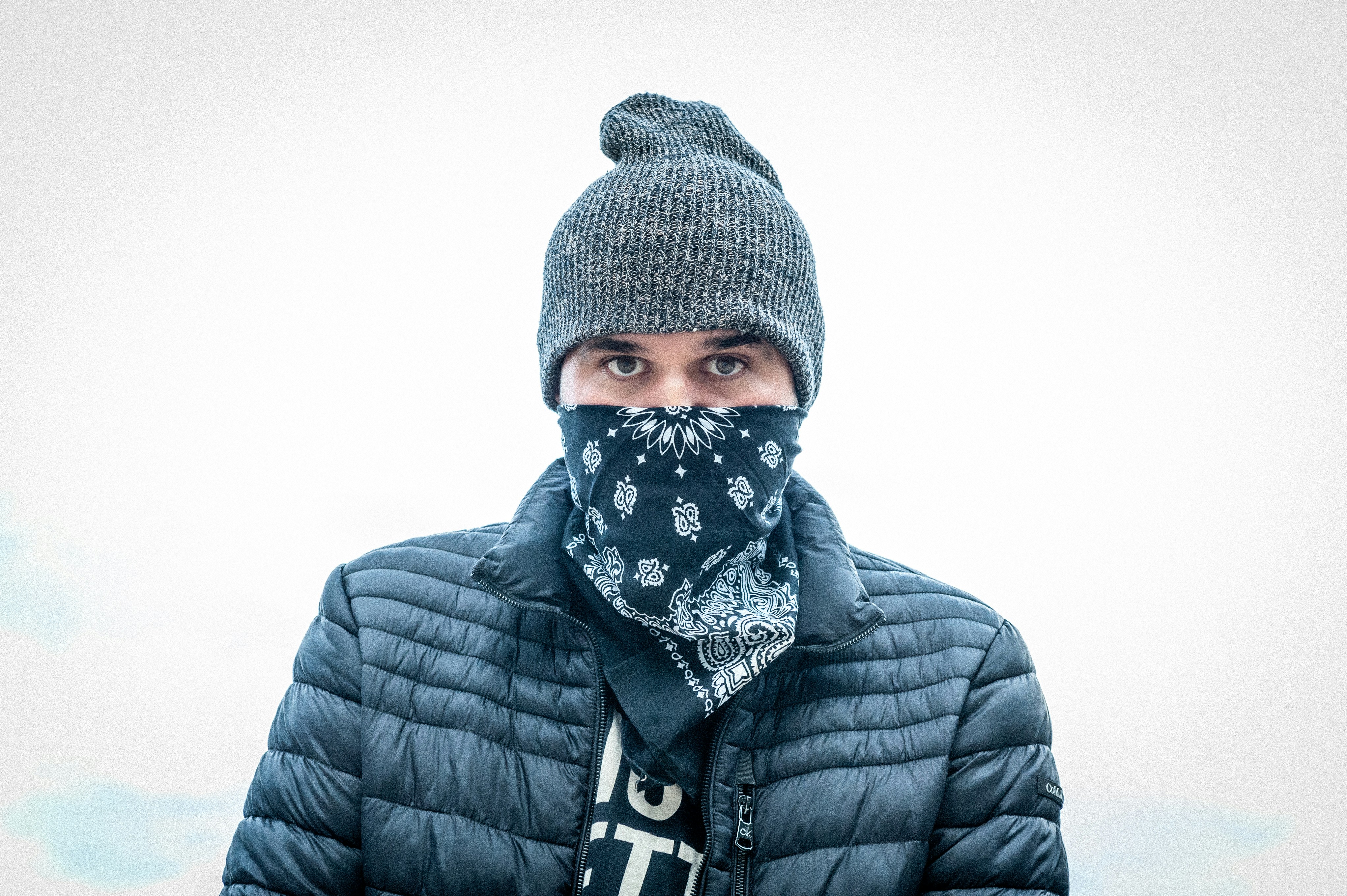 persona in giacca nera e berretto in maglia nera