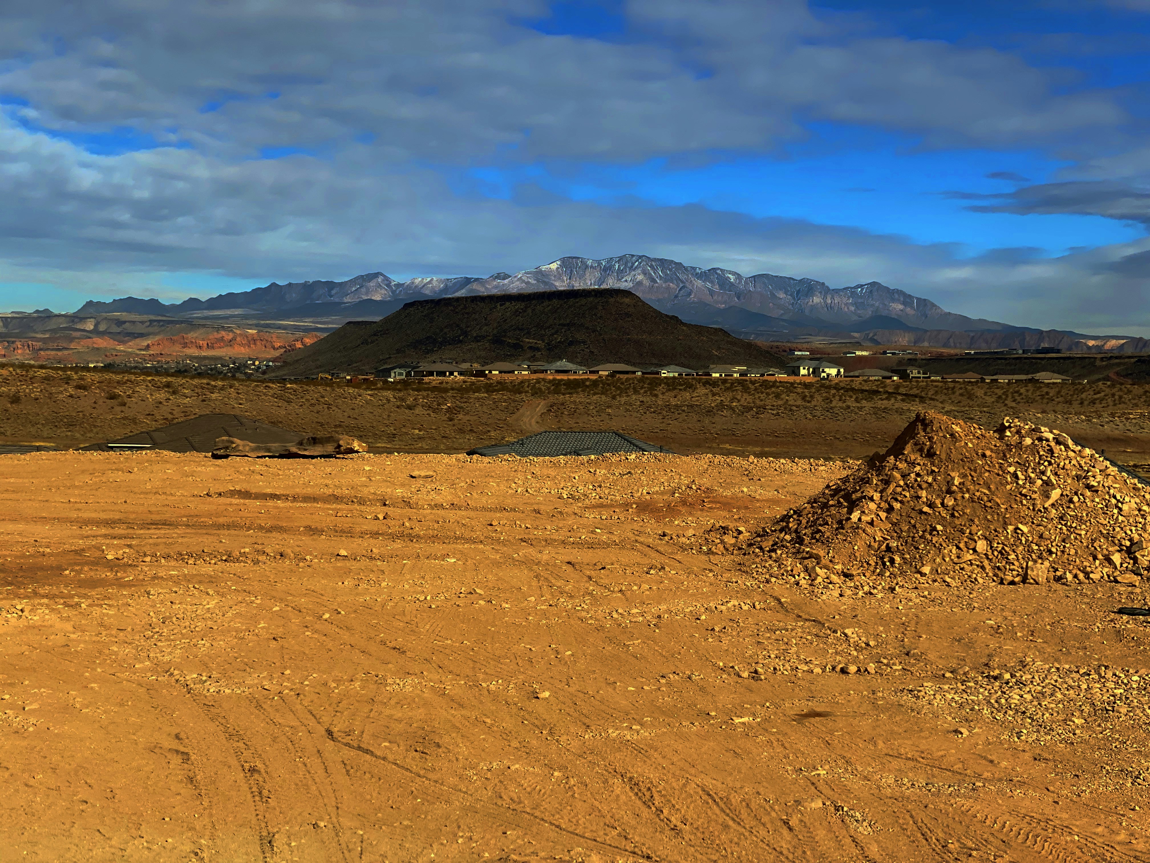 Leh Ladakh high altitude desert landscape with barren mountains, blue sky, remote dramatic terrain, Buddhist monastery in distance
