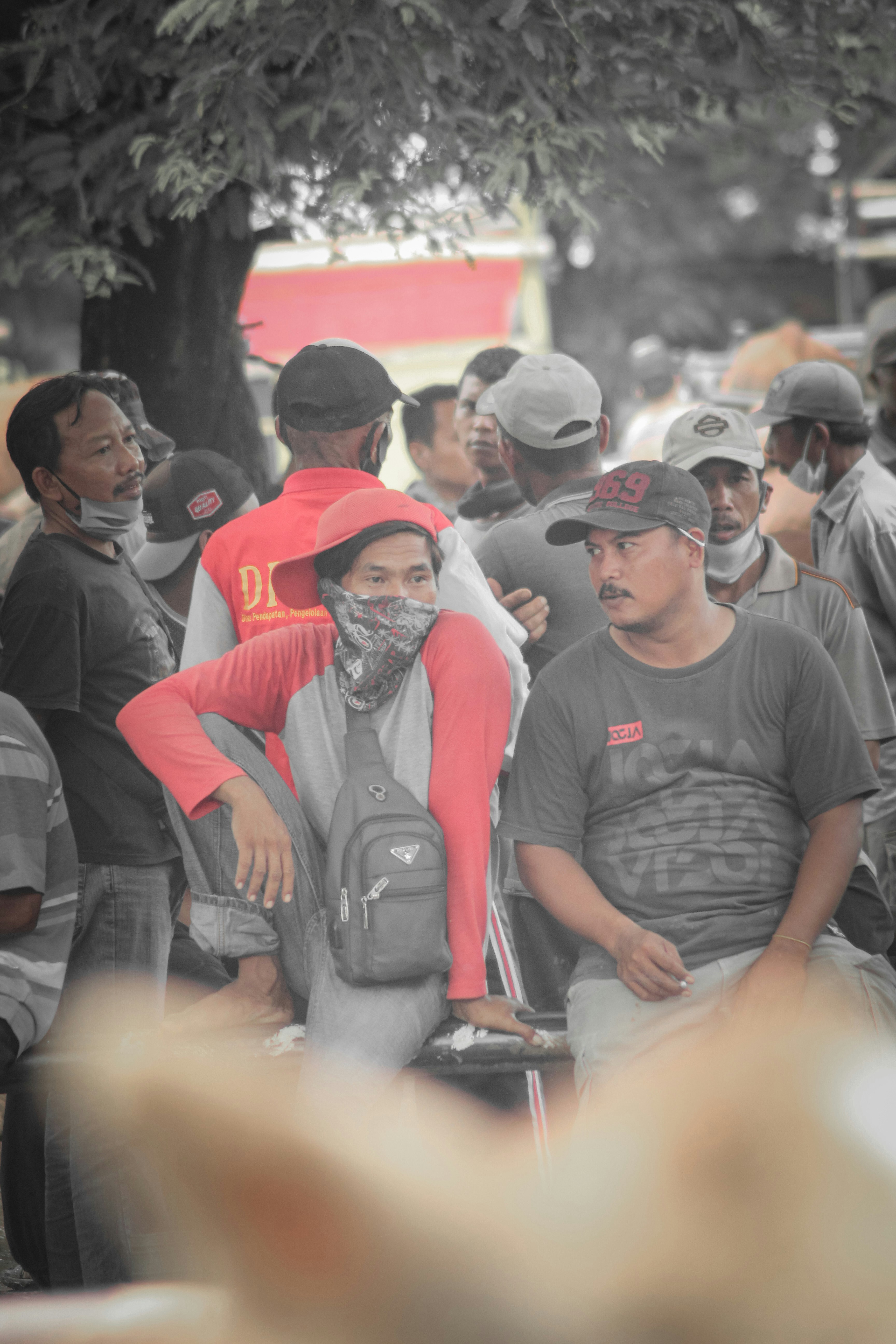 Pria berbaju leher kru hitam berdiri di samping wanita dengan jaket merah