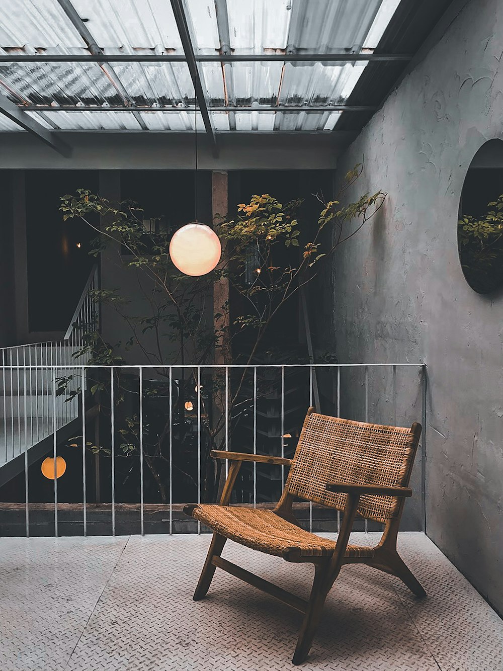 brown wooden armchair beside black metal fence