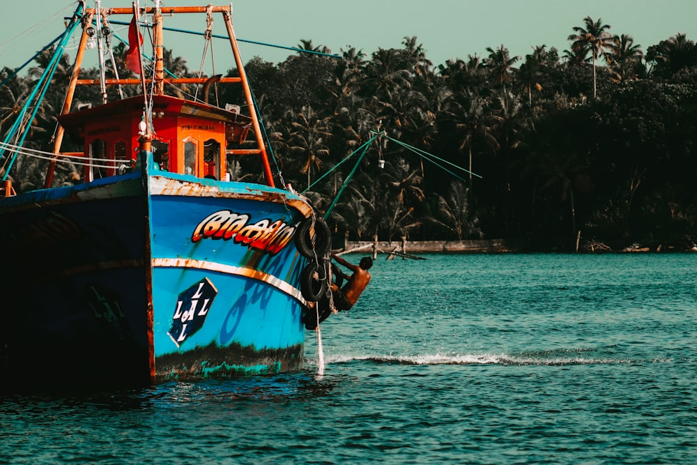 red and black boat on body of water during daytime