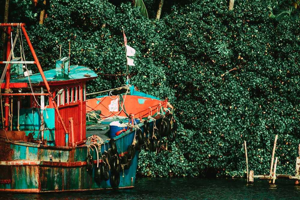 blue and red boat on body of water during daytime