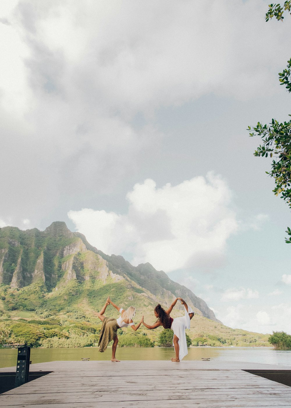 3 women standing on green grass field near green mountain during daytime