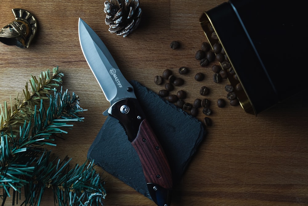 brown and silver folding knife on brown wooden table
