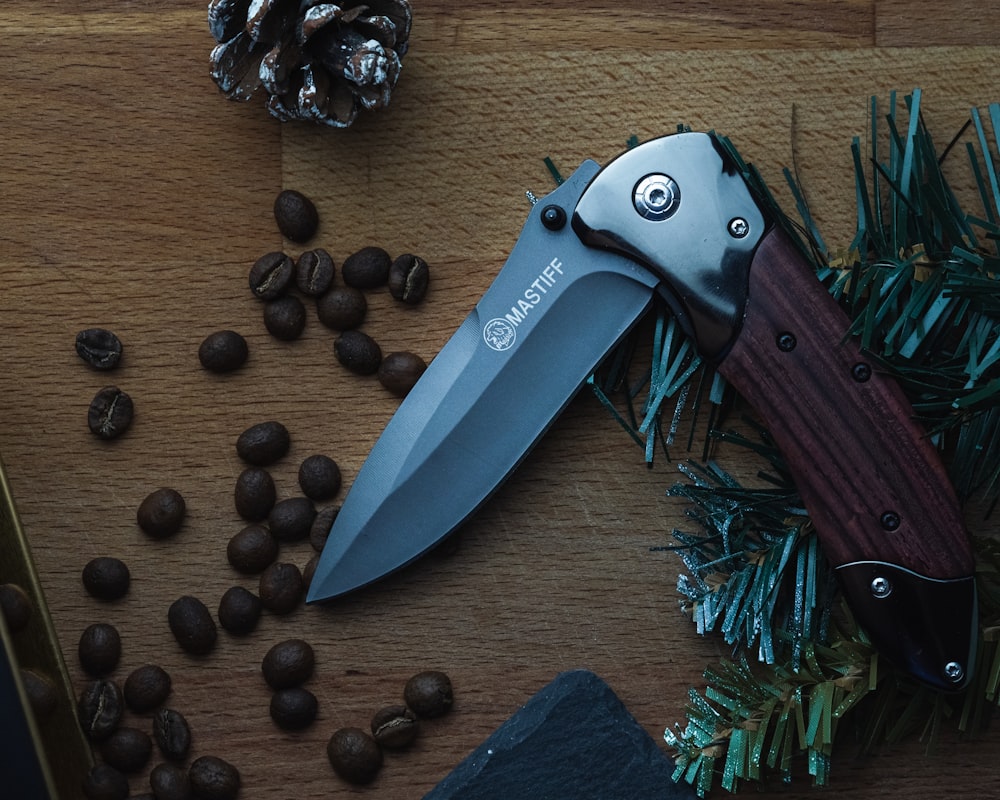 black and silver pocket knife on brown wooden table