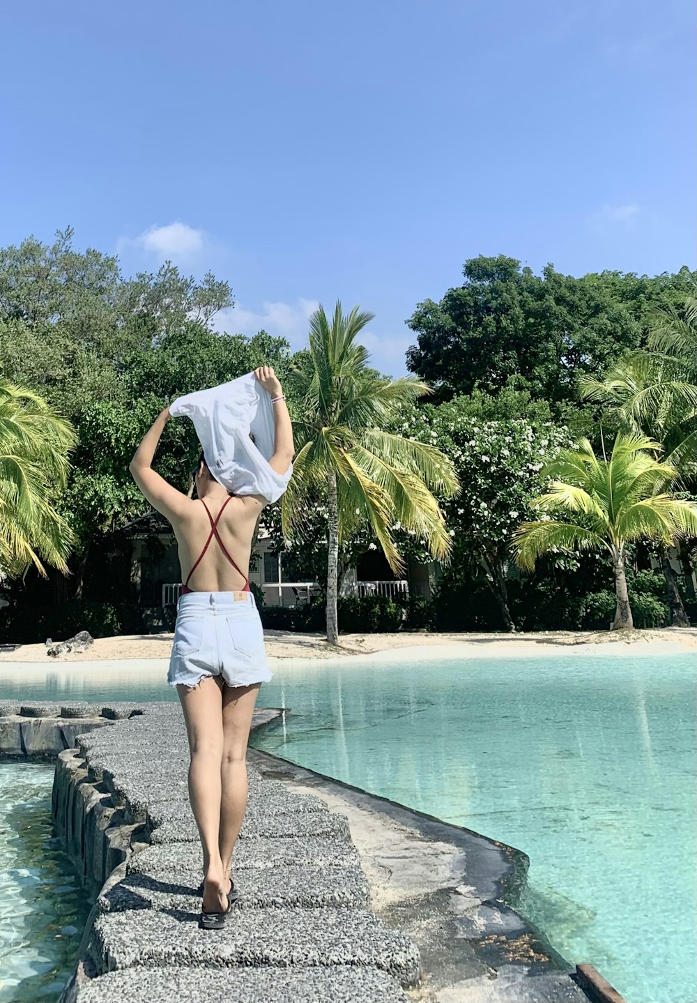 woman in white bikini standing on swimming pool during daytime