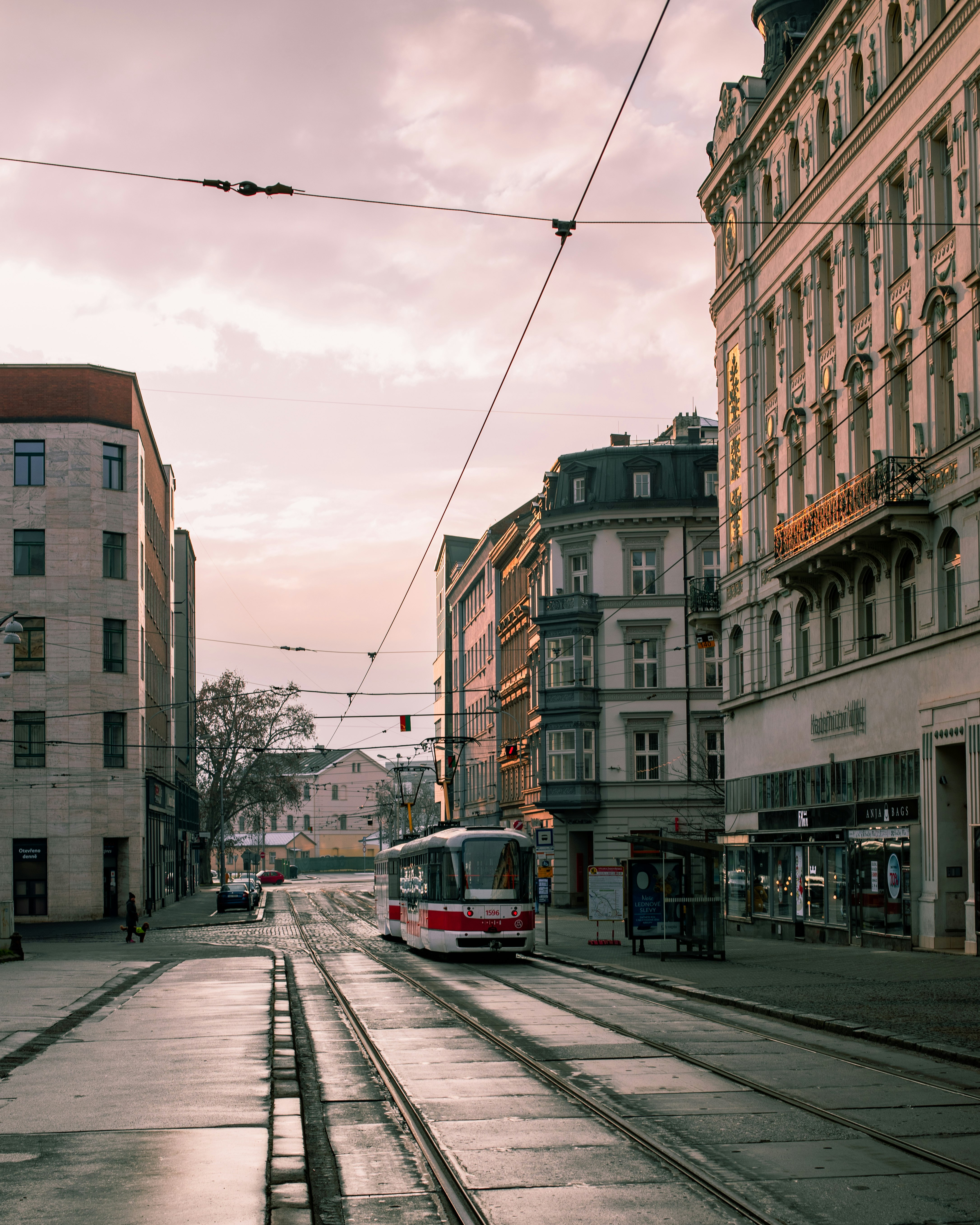 red and white tram on road near brown concrete building during daytime