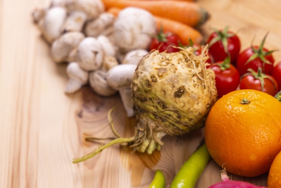 A vibrant assortment of fresh vegetables and fruits displayed on a wooden table.