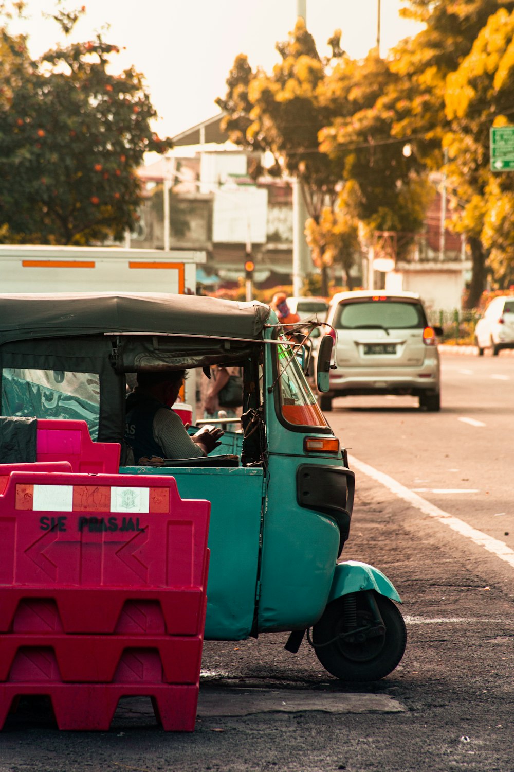 man in blue t-shirt driving pink car during daytime