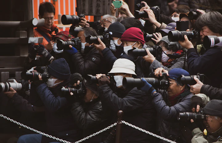 Photographers with their cameras raised