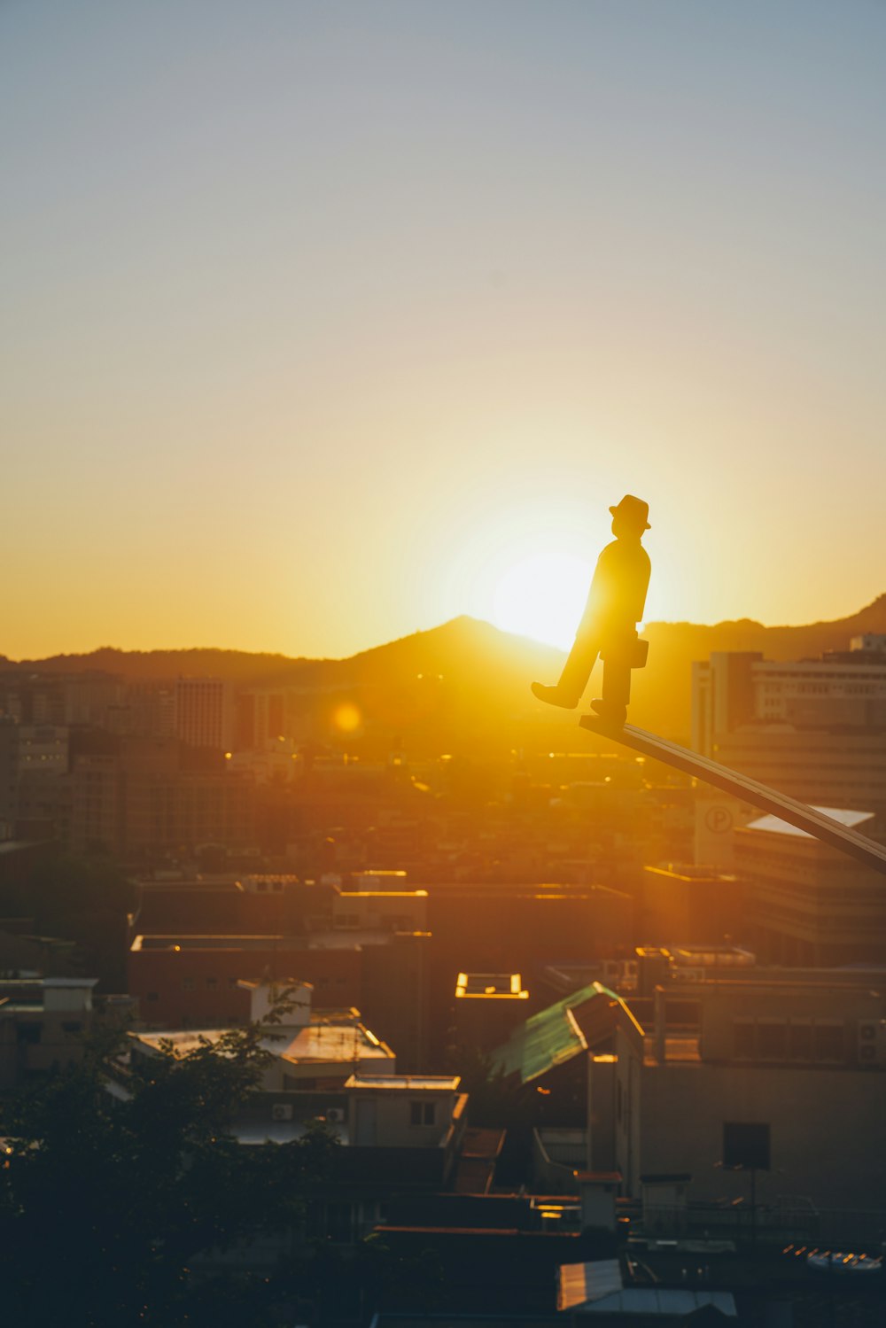 silhouette of man standing on top of building during sunset