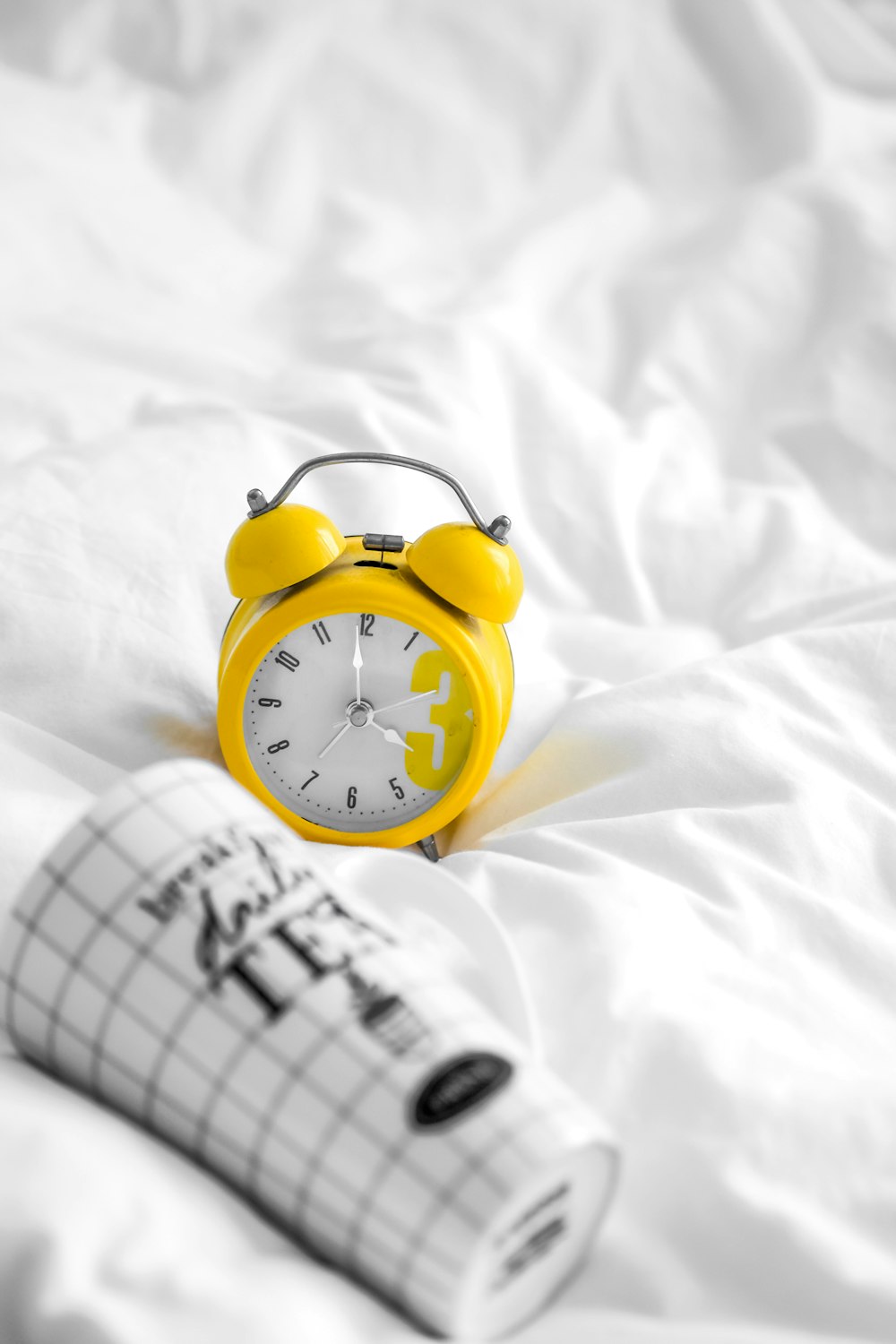yellow and white analog alarm clock at 10 10