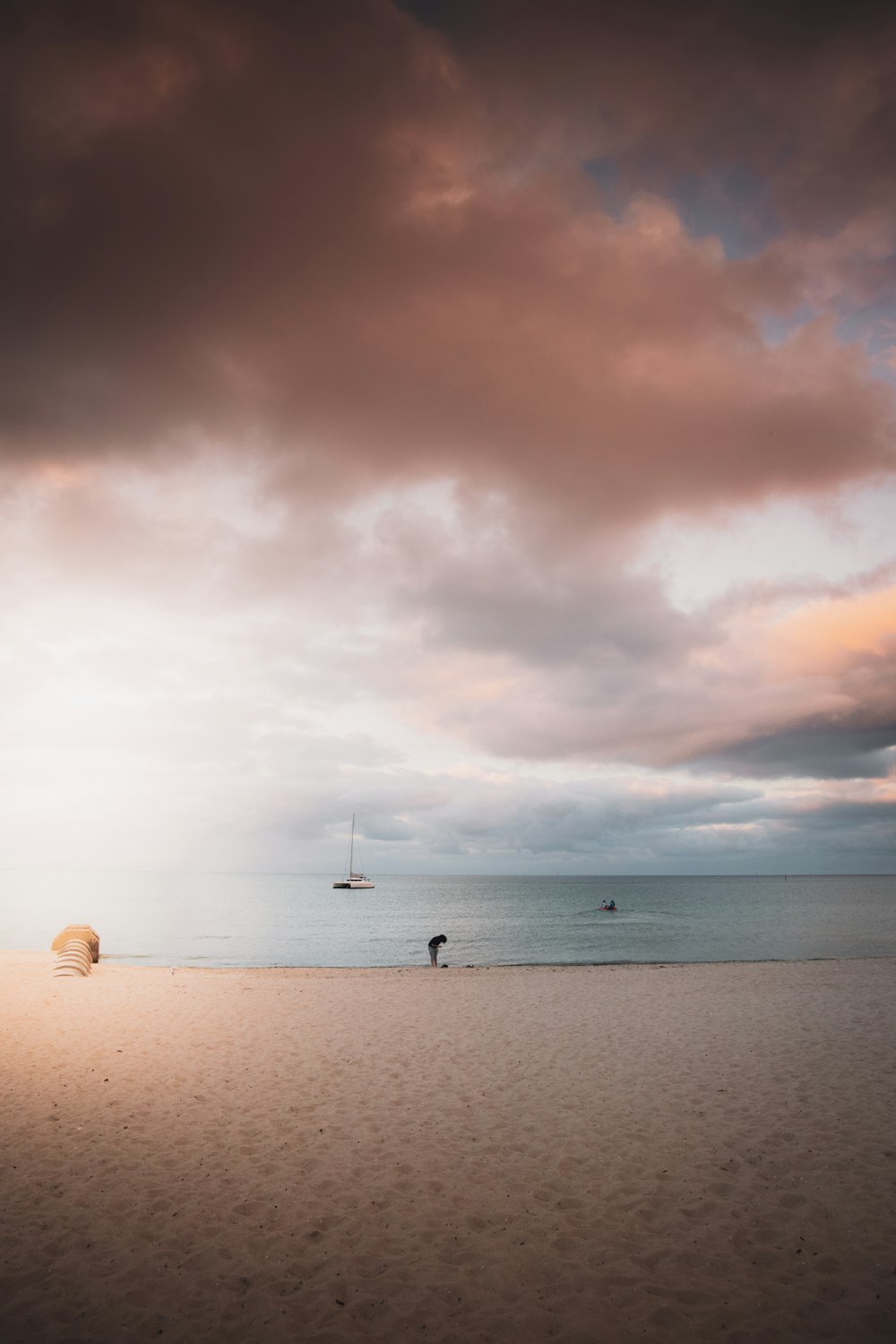 person in black shirt walking on white sand beach during daytime