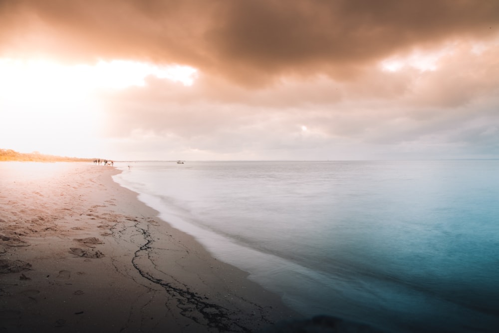 sea waves crashing on shore during sunset