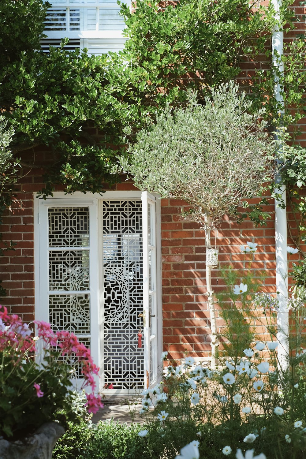 white and brown concrete house with white wooden window frame