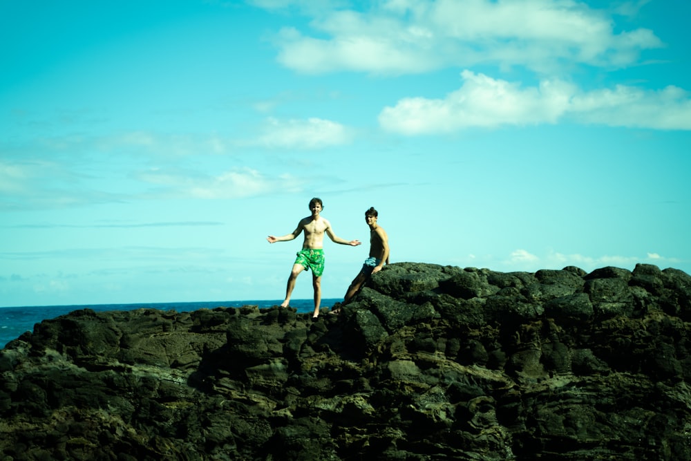 2 women standing on rock formation during daytime